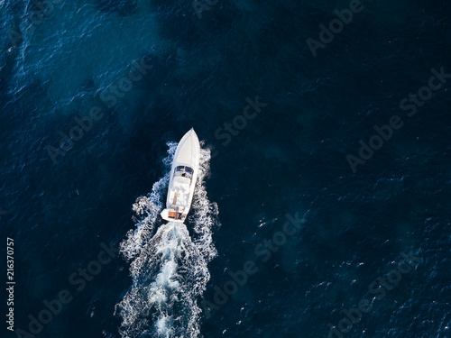 View from above, aerial view of a yacht sailing on an emerald and transparent Mediterranean sea. Emerald coast (Costa Smeralda), Sardinia, Italy.