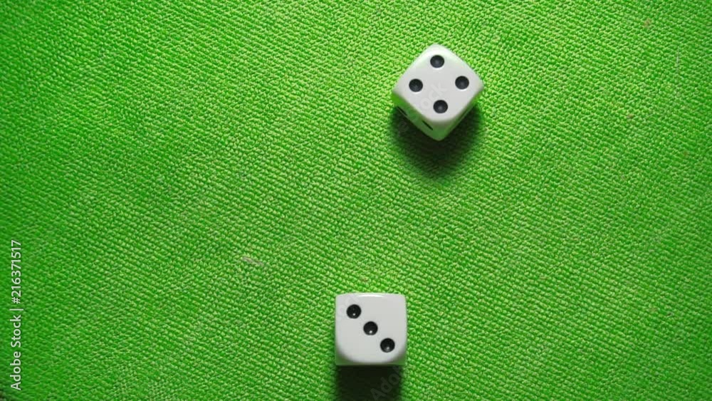 Rolling a lucky seven with a pair of white dice on a green casino gaming table.