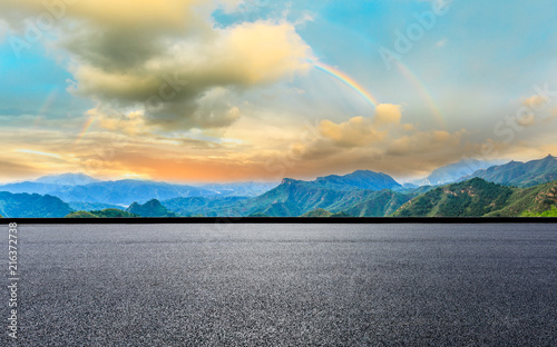 Empty asphalt road and mountain with rainbow natural landscape at sunrise © ABCDstock