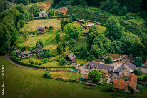 Obraz na płótnie A vantage point view over a small farm in Ardennes, Belgium, with a miniature-like look and feel w salonie