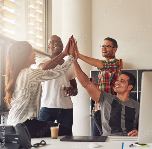 Happy workers putting hands together for a win photo