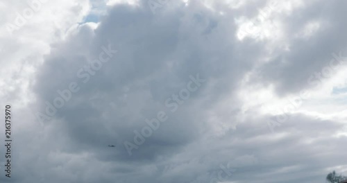 Wallpaper Mural Plane flying left to right below grey storm clouds Torontodigital.ca