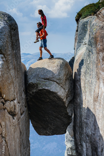 Crazy partner piggybacking his lady, she rides him romantic trip in Norway Kjerag mountains vacations adventure lifestyle family man and woman together extreme journey concept.