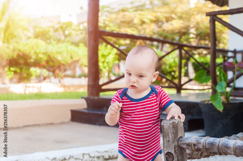 Thoughtful kid in red bodysuit on vacation Thoughtful kid in red bodysuit on vacation