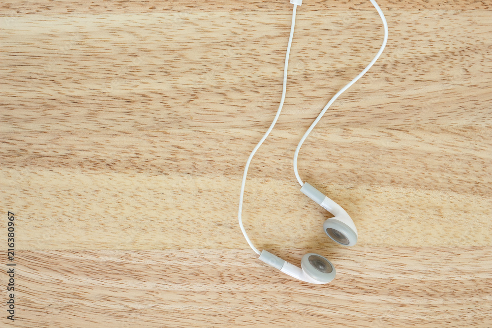earbuds or earphones on wood background