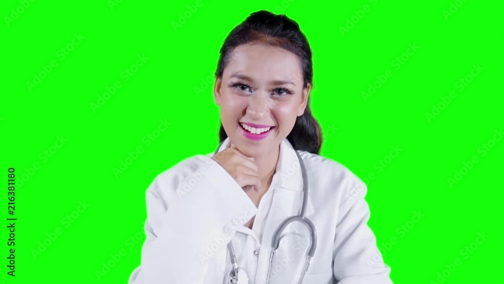 Slow motion of pretty female doctor smiling at the camera with green screen background Slow motion of pretty female doctor smiling at the camera with green screen background