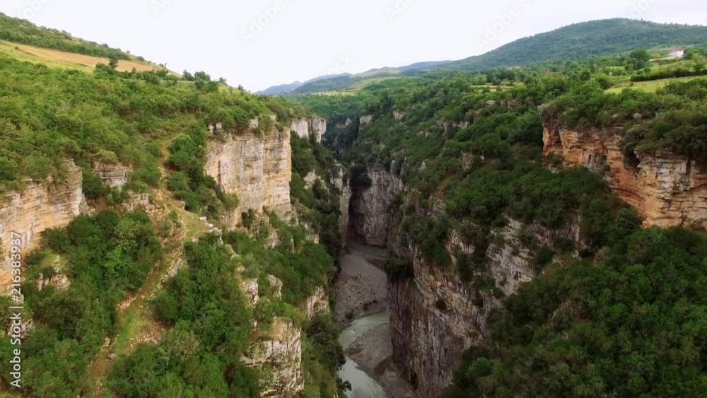 Aerial drone of Albania Osum River through the canyon. Lots of green forest tress on the side of the mountain With a river traveling in-between the 2 mountains. Aerial drone of Albania Osum River through the canyon. Lots of green forest tress on the side of the mountain With a river traveling in-between the 2 mountains.