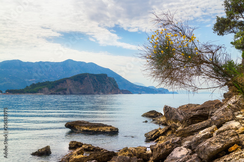 Mogren beach with big stones and Sveti Nikola island at Adriatic sea coastline in Montenegro