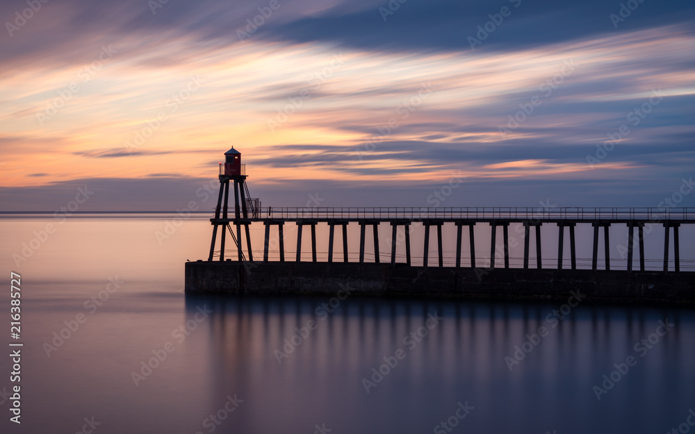 Sunrise at Whitby East Pier Lighthouse, Yorkshire, UK
