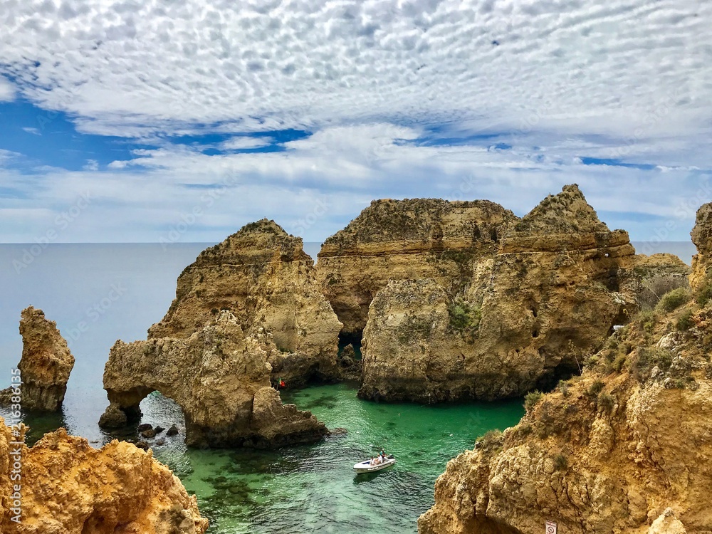 Algarve landscape with yellow rocks, sky and Atlantic ocean. Portugal Atlantic coast with turquoise watercolor in the ocean.