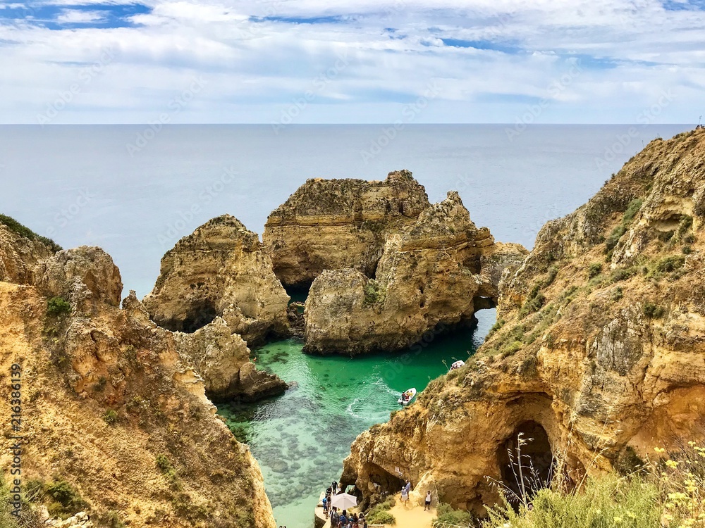 Algarve landscape with yellow rocks, sky and Atlantic ocean. Portugal Atlantic coast with turquoise watercolor in the ocean.