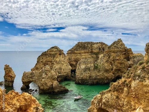 Algarve landscape with yellow rocks  sky and Atlantic ocean. Portugal Atlantic coast with turquoise watercolor in the ocean.