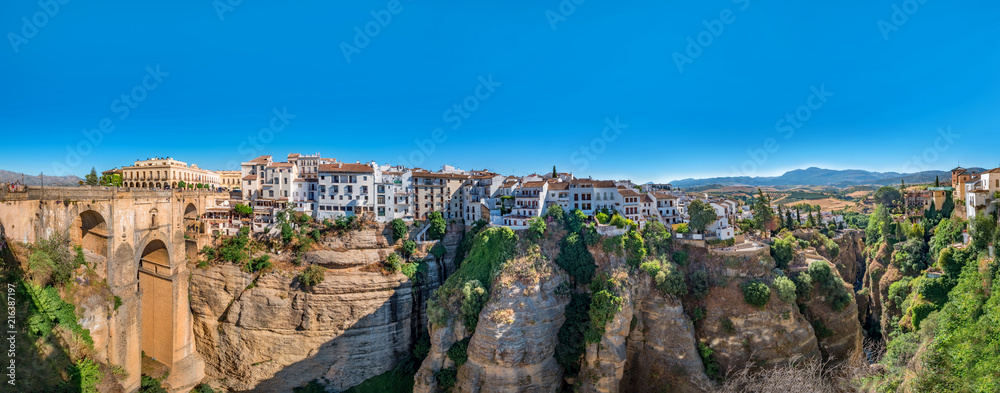 Panorama view of the Puente Nuevo bridge and the houses built on the edge of the cliff, in the ancient city of Ronda, Spain