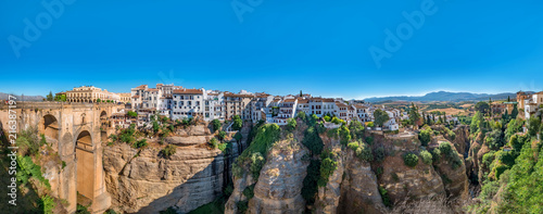 Panorama view of the Puente Nuevo bridge and the houses built on the edge of the cliff, in the ancient city of Ronda, Spain photo