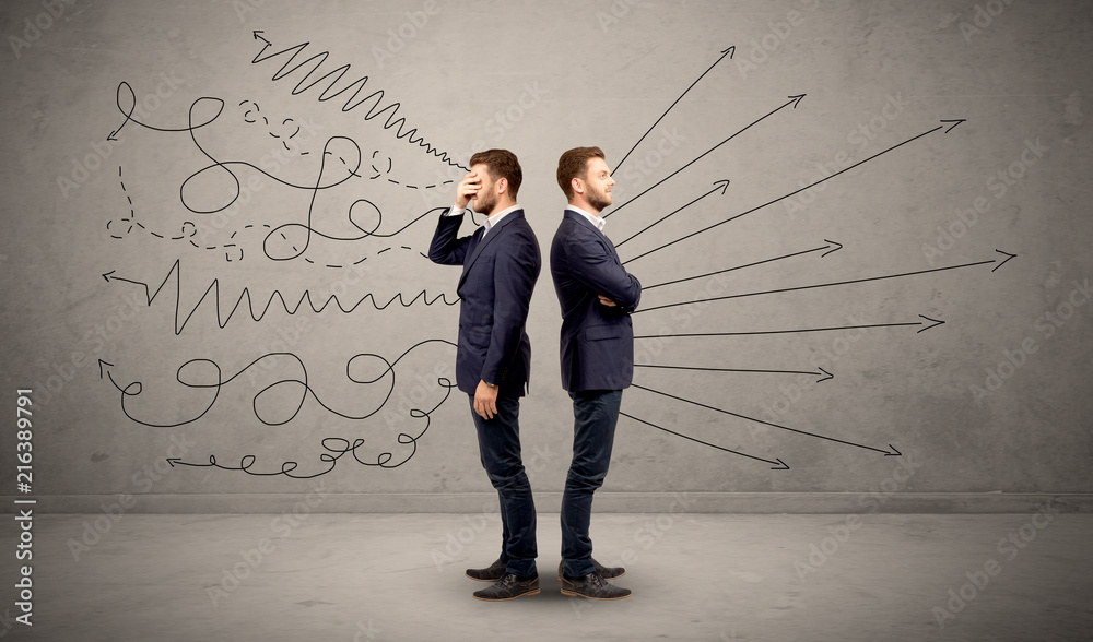 Young conflicted businessman choosing between two directions with arrows and scribbles around him Young conflicted businessman choosing between two directions with arrows and scribbles around him