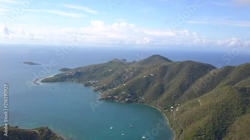 Slow-paced drone flight towards the island of St. John, overlooking sailboats and hilly terraine photo