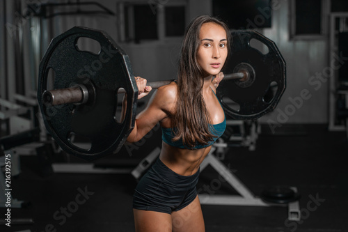Female training with barbell, pumping legs