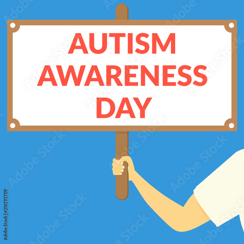 AUTISM AWARENESS DAY. Hand holding wooden sign