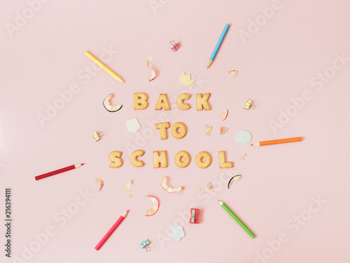 Colorful background with lettering Back to School made of cookies on pink pastel background, school concept