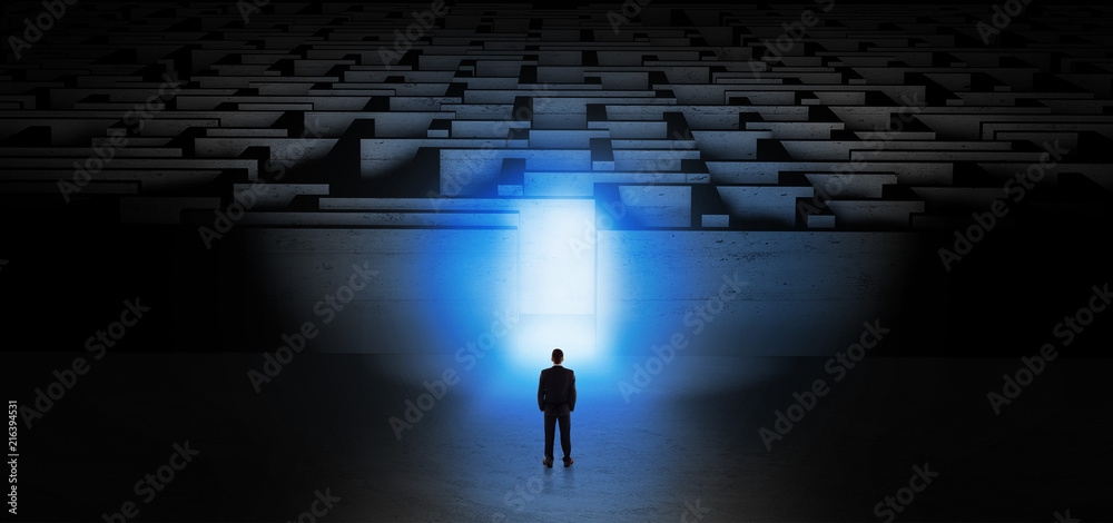 Businessman getting ready to enter the dark labyrinth with illuminated door
