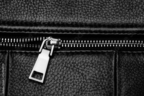 Black leather bag with silver zipper. Close-up of black leather.
