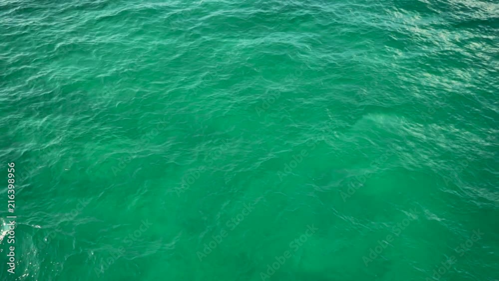 slow motion tracking shot from above of beautiful clean light blue ocean water. Water shimmering as it ripples slow motion tracking shot from above of beautiful clean light blue ocean water. Water shimmering as it ripples