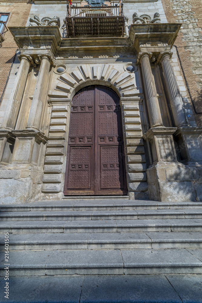 huge medieval wooden door with tall stone columns, medieval church in the city of Toledo, Spain