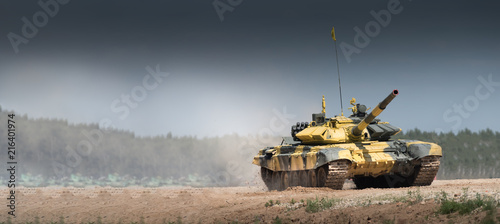 Military or army tank ready to attack and moving over a deserted battle field terrain. a lot of dust. copyspace photo
