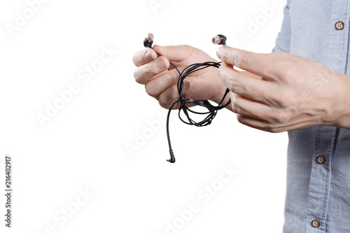 Person trying to untangle headphone wires, isolated on white background photo