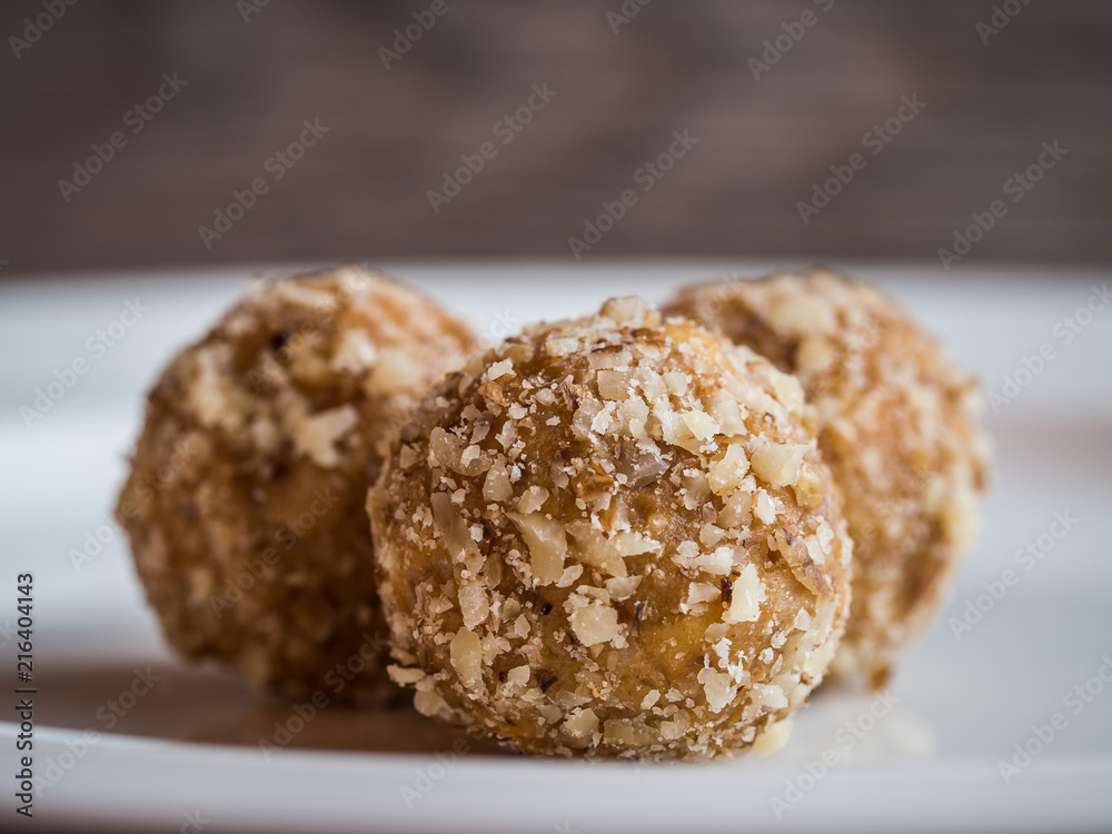 Homemade walnut balls on a white plate, traditional Christmas sweets close up Homemade walnut balls on a white plate, traditional Christmas sweets close up