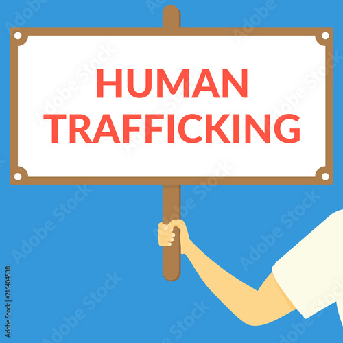 HUMAN TRAFFICKING. Hand holding wooden sign