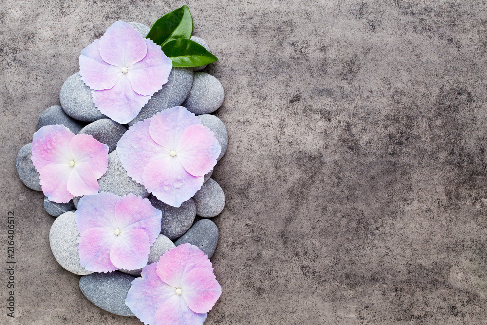 Obraz premium Spa flowers and massage stone, on grey background.