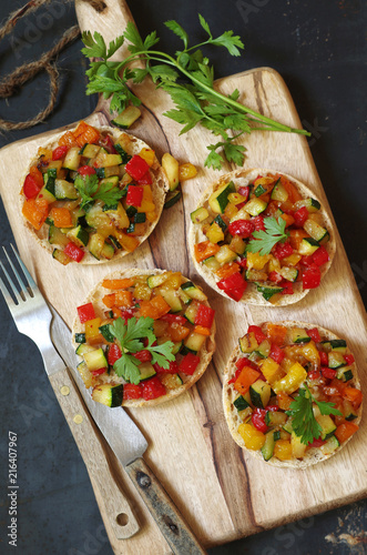 kleine Brötchenpizzen mit buntem Zucchini-Paprika Gemüse und Parmesan