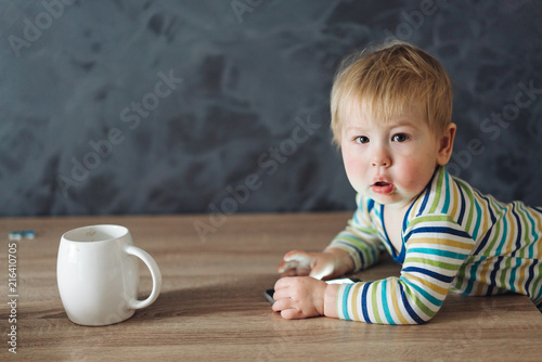 baby boy standing near the table photo