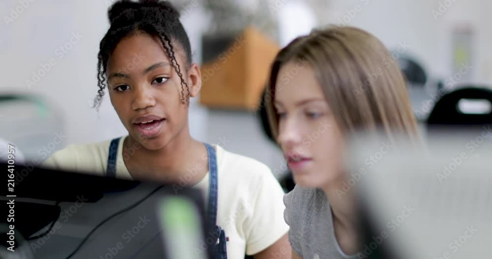 Closeup teenage girls using a computer in class Closeup teenage girls using a computer in class