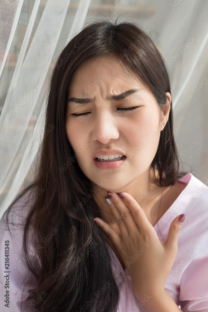 sick woman with sore throat; portrait of woman suffering from cold, flu, sickness with sore throat inflammation; female body care, sickness, allergy, pain concept; asian 20s young adult woman model sick woman with sore throat; portrait of woman suffering from cold, flu, sickness with sore throat inflammation; female body care, sickness, allergy, pain concept; asian 20s young adult woman model