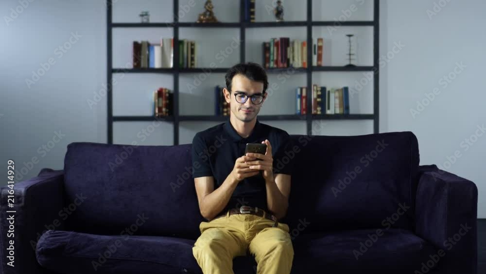 Young businessman using digital device online shopping working from home, Sitting on Sofa Young businessman using digital device online shopping working from home, Sitting on Sofa