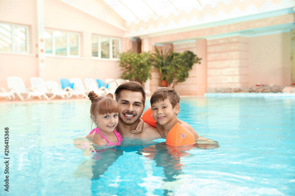 Happy father with children in swimming pool Happy father with children in swimming pool