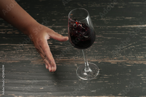 kieliszek czerwonego wina i dłoń