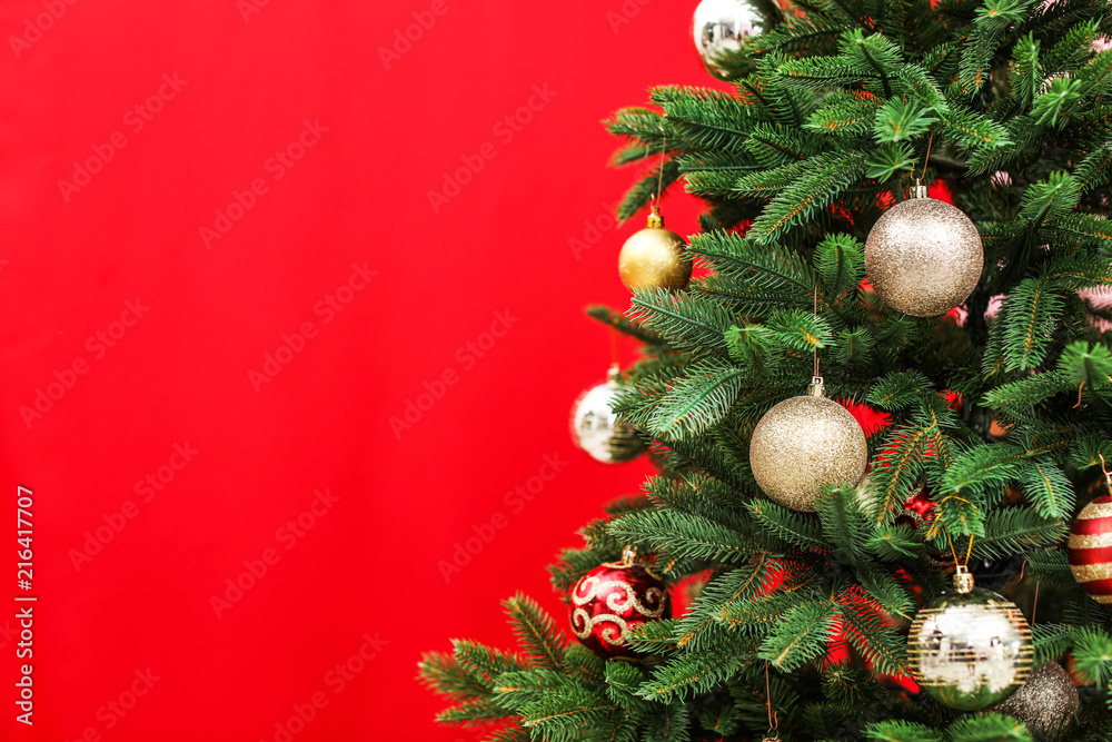 Beautifully decorated Christmas tree against color background, closeup