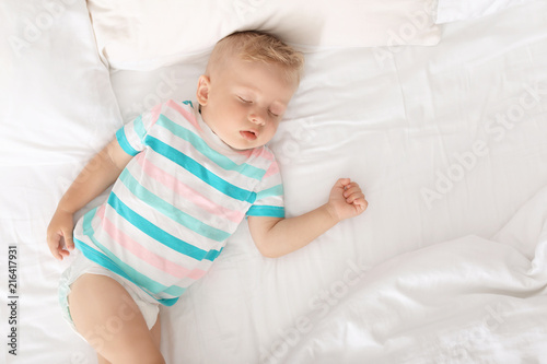 Little child sleeping on bed at home