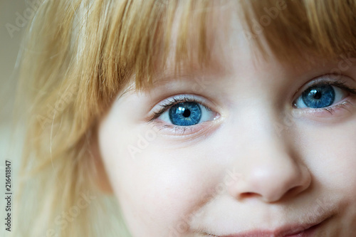 blue baby eyes closeup. smiling little blonde girl portrait