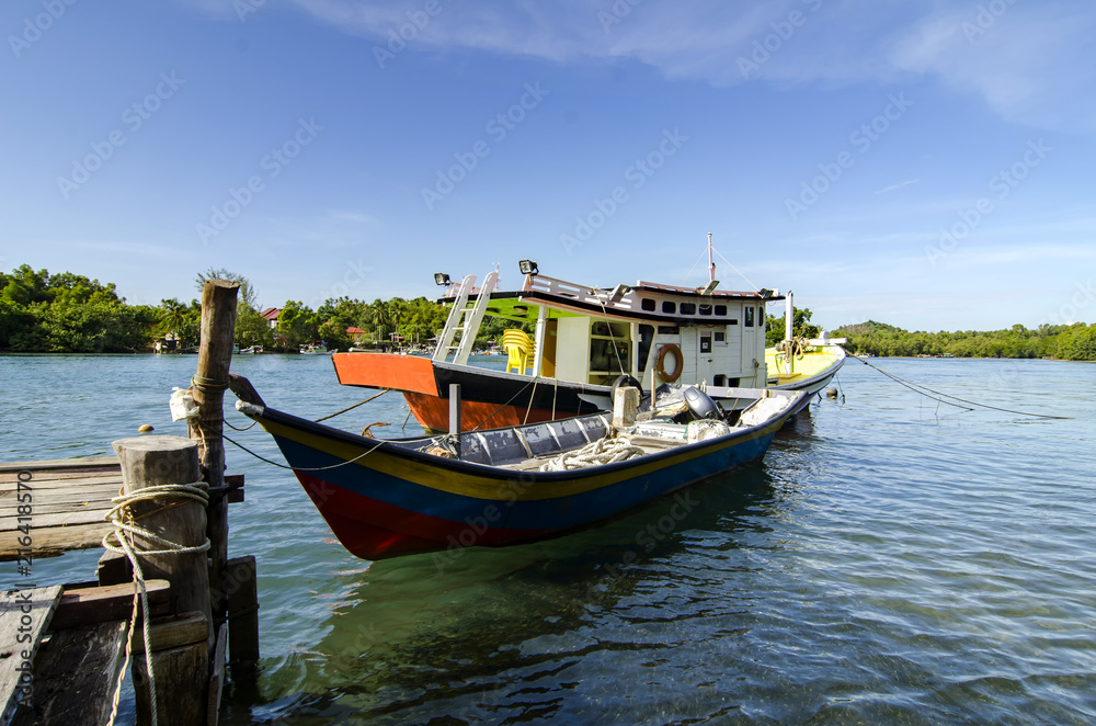 traditional malaysian fisherman boat moored near the riverbank over blue sky background