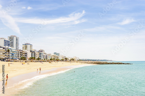 Εκτύπωση καμβά People walking along seaside in Quarteira during sunny day, Algarve, Portugal