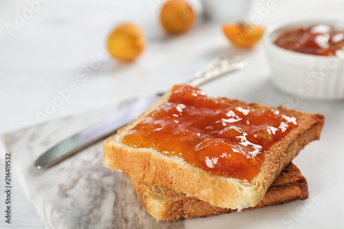 Bread with tasty apricot jam on board