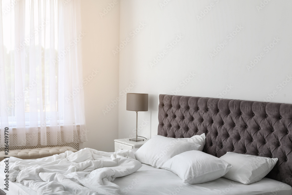 Soft white pillows on comfortable bed indoors