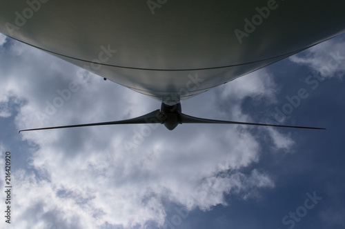 Windkraftanlage von unten mit Propeller Wolken und Himmel
