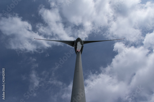 Windkraftanlage mit Blick von unten auf Propeller und Himmel mit Wolken