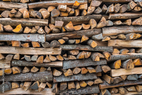 Preparation of firewood for the winter. firewood background, Stacks of firewood in the forest. Pile of firewood