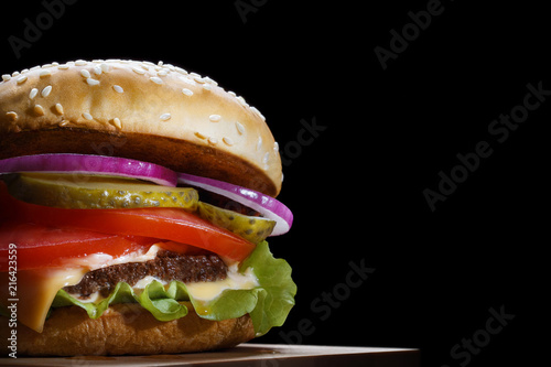 Delicious tasty burger, isolated on black background photo